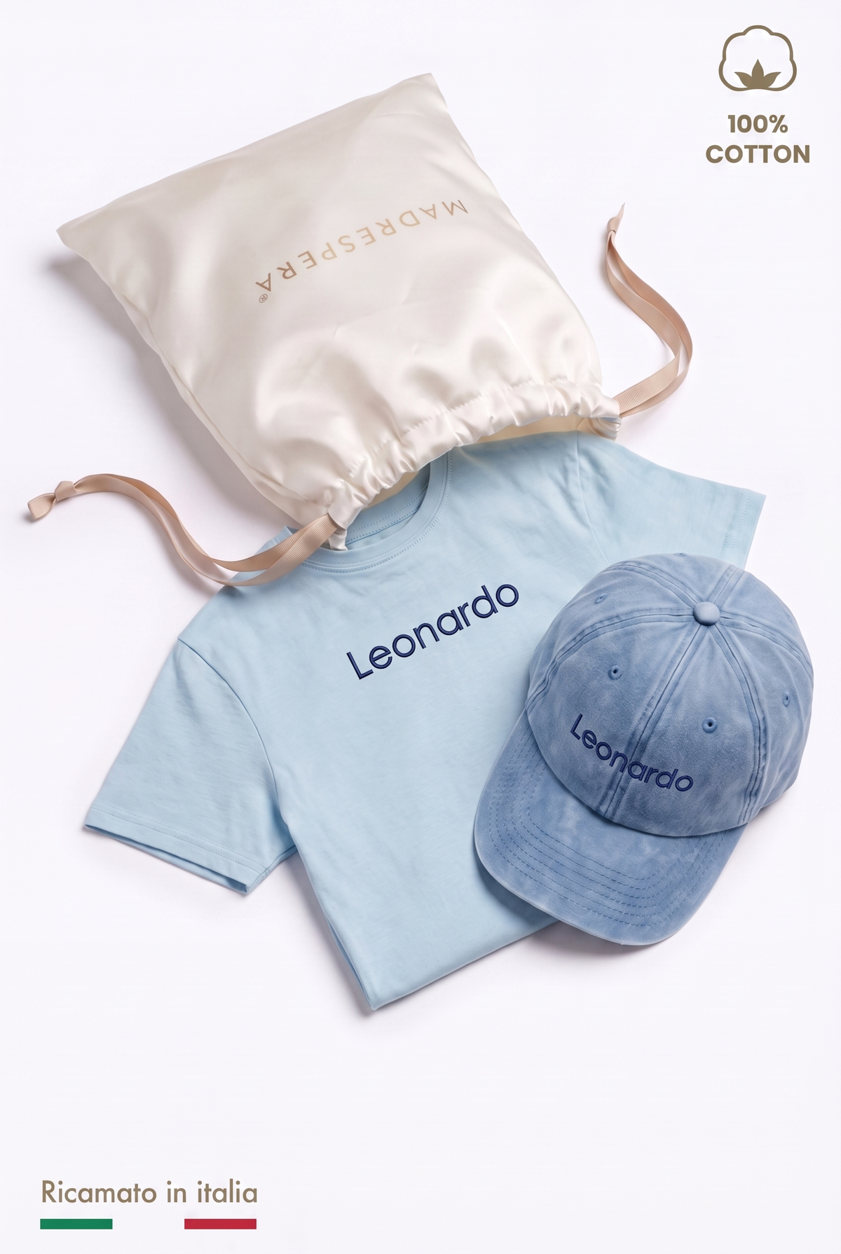 Box MADRESPERA: sacca regalo in raso aperta con la t-shirt azzurra e il cappellino con il nome Leonardo ricamato in filo blu