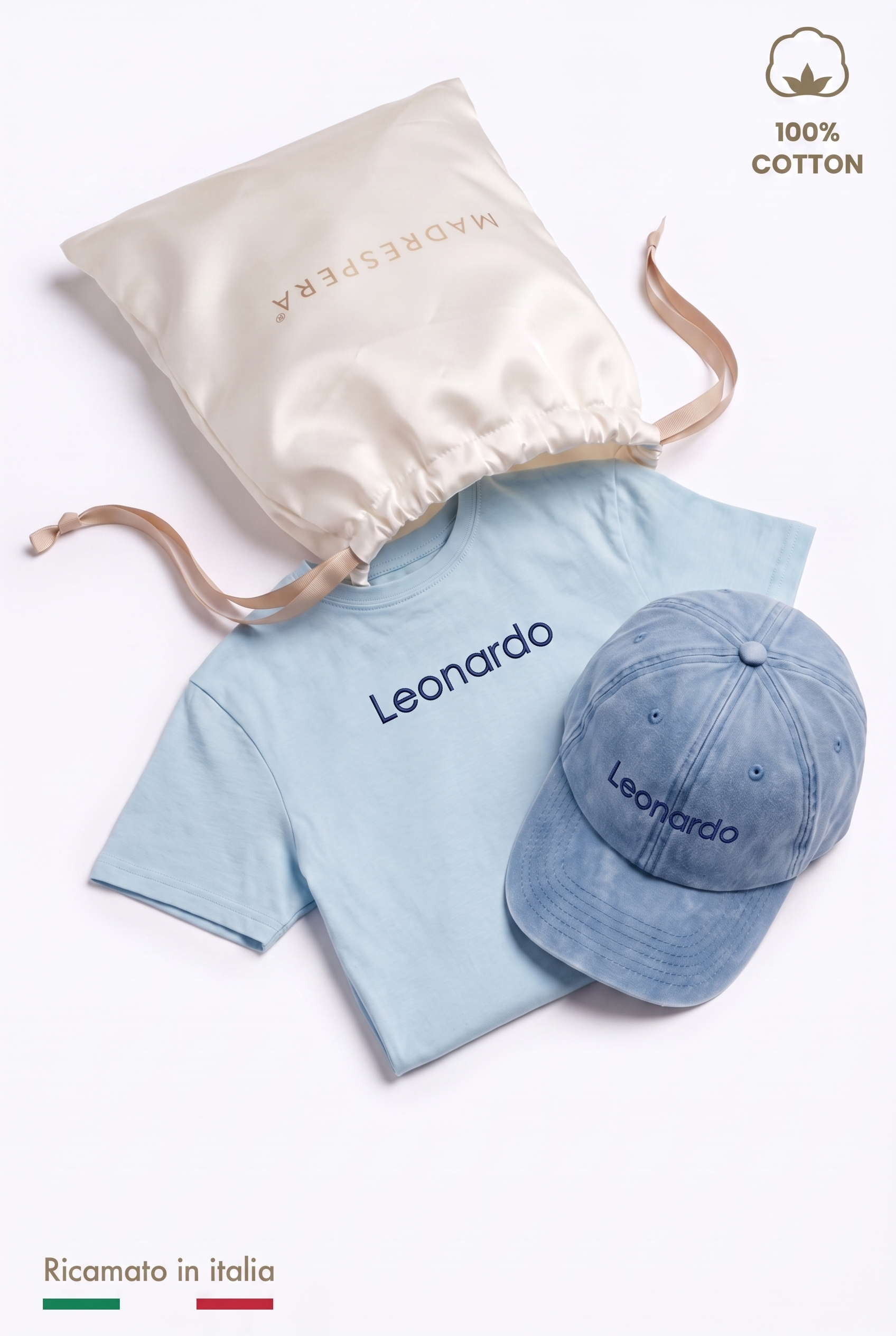 Box MADRESPERA: sacca regalo in raso aperta con la t-shirt azzurra e il cappellino con il nome Leonardo ricamato in filo blu