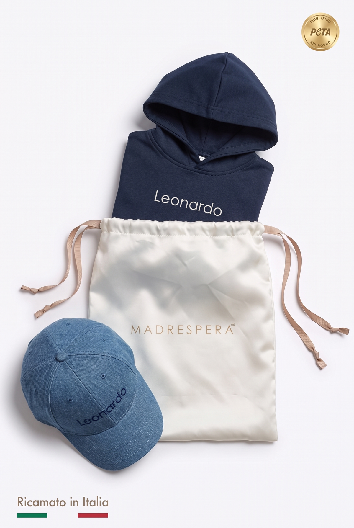 Box MADRESPERA: sacca in raso avorio con logo, felpa con cappuccio blu navy e cappellino con il nome Leonardo ricamato